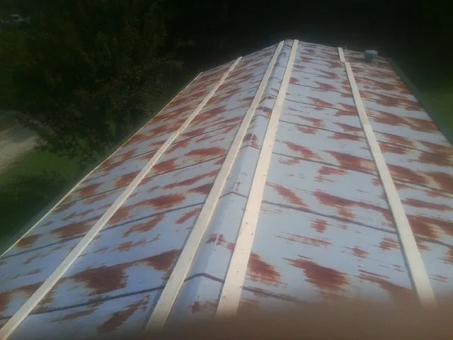 Rusted metal roof panels with new wood purlins before replacement — Storm Damage Roof Repair in Mingo Junction by Roofing Brothers